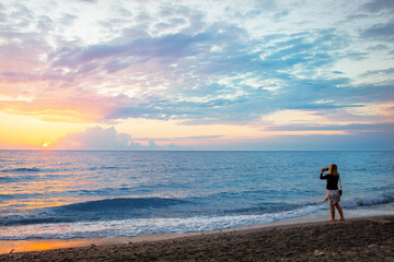 Woman making photo at sunrise (sunset)