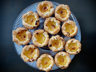 Portugese pastries - pasteis de nata on a glass plate. Delicious home made cuisine that is typical for the Lisbon region.
