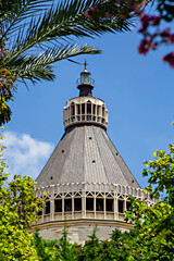 Nazareth, Israel. Jule 26, 2020: the dome of the Basilica of the Annunciation through the trees,...