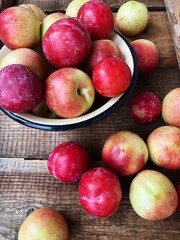 Ripe nectarines and red plums on the table