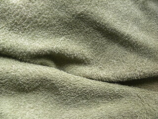 Green color cotton towel background with wrinkles