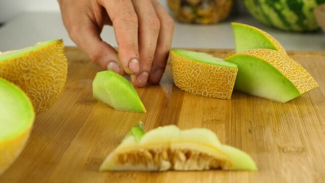 Precision slicing is used to take the hard skin off of galia melon chunks.
