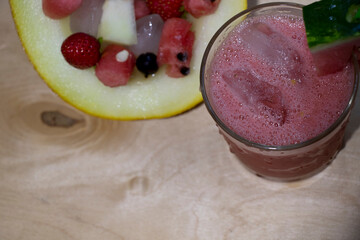Watermelon smoothie with ice in a glass cup and a slice of watermelon on top. Summer drink.