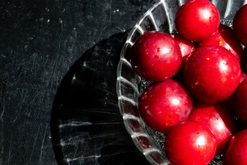 red plums with a black wooden background 