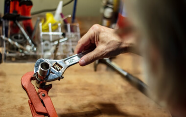 Male using a wrench tool to tighten a metal pipe part