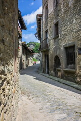 Fototapeta na wymiar On the atmospheric paved street and Rustic house in the medieval village of Rupit in the mountainous part Catalonia. Spain.