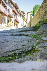 Fototapeta na wymiar On the atmospheric paved street and Rustic house in the medieval village of Rupit in the mountainous part Catalonia. Spain.