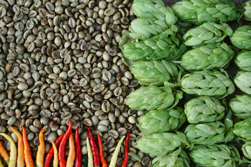 Hop twigs, green coffee beans, red chili  over wooden cracked table background. Vintage toned.