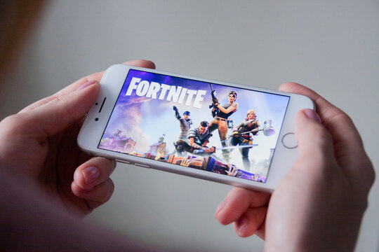 Los Angeles, California, USA - 8 March 2019: Hands holding a smartphone with Fortnite game on display screen, Illustrative Editorial