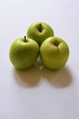 Three ripe green Granny Smith apples on white background with copy space