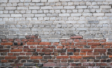 old dilapidated wall of white and red brick