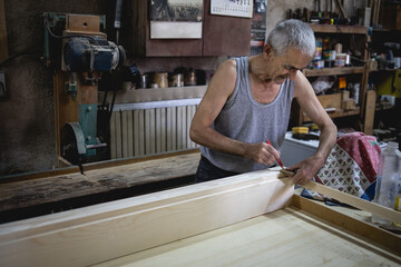 Older man, carpenter in his workshop