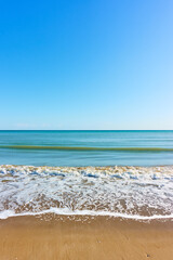 Sea beach with surf and blue sky