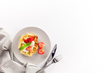 Homemade belgian waffles on served table on white background top view