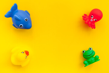 The concept of children’s bath toys. Yellow background top view copyspace