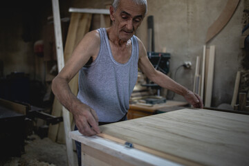 Older man, carpenter in his workshop
