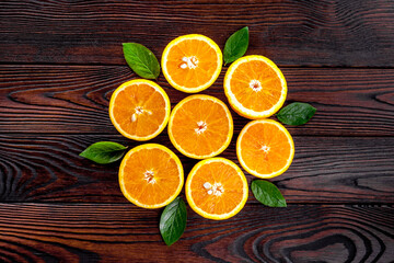 Concept of orange slices with leaves on dark wooden background top view flat lay copy space