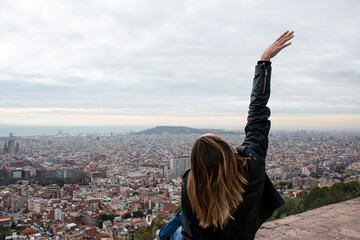 happy girl enjoys the views of a viewpoint in the city of Barcelona