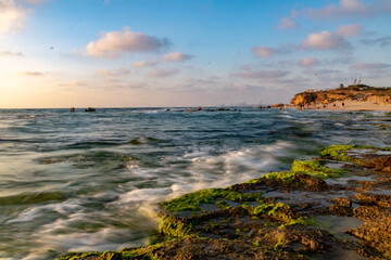 water splash on rocks sunset over the sea