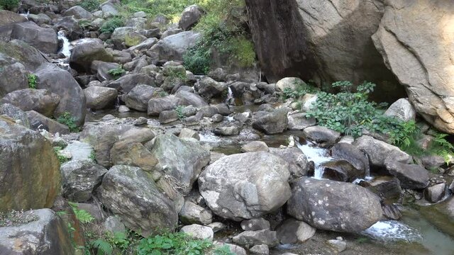 Waterfall passing through rocks and green vegetation. Footage shot at Jhalong, Dooars, West Bengal - India.