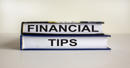 Books with text 'financial tips' on beautiful white table. White background. Business concept. Copy space.
