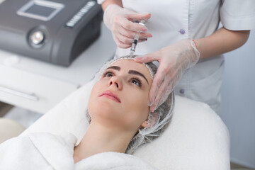 Obraz na płótnie Canvas Woman gets injection in her face. Beauty woman giving botox injections. Young woman gets beauty facial injections in the cosmetology salon. Face aging injection. Aesthetic Medicine, Cosmetology