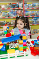 Little girl playing with construction blocks