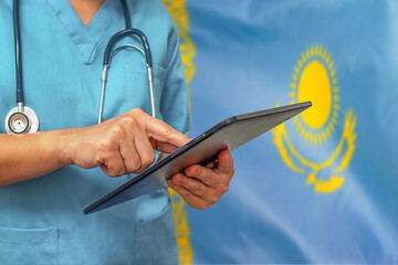 Surgeon or doctor using a digital tablet on the background of the Kazakhstan flag.