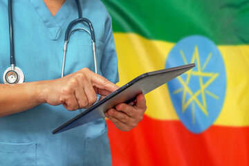 Surgeon or doctor using a digital tablet on the background of the Ethiopia flag.