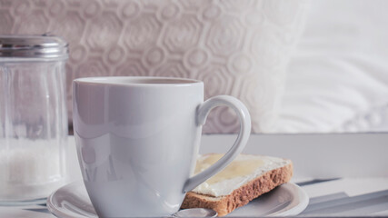 Primer plano de una taza de cerámica blanca con café espumoso sobre una bandeja con estilo y de...