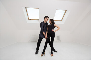 beautiful couple dancing bachata on white background in studio