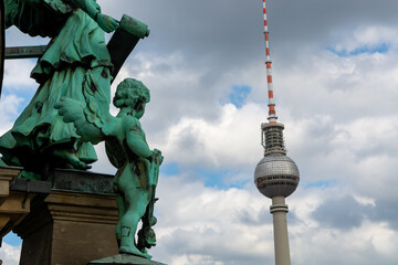 Berlin Germany statue of cupid on cathedral looking at TV Tower called Fernsehturm in German