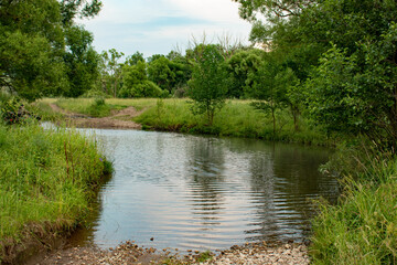 Small river among green hills and forests, beautiful water.