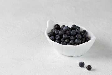 Blueberries in a white cup on a white background