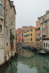 Fototapeta na wymiar canal in venice italy with bridge and boats in winter fog
