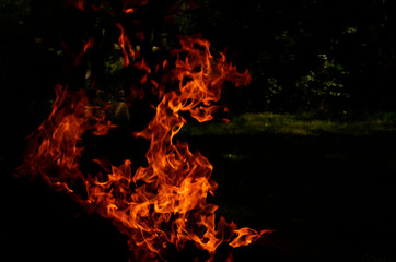 Texture of orange and red flames from a wood fire outdoors, template for graphic use of flames or fire, wallpaper and fire background isolated on black background