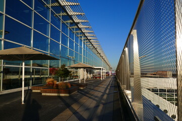 Terrace with modern architecture, security wire nets under blue sky and shadow structures on the floor.