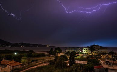 Lightning cuts the dark blue and purple sky above the sea
