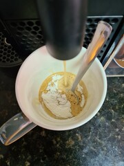 pouring coffee and milk into a bowl