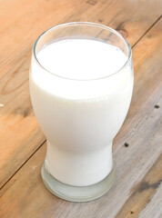 Glass of milk isolated on wooden board