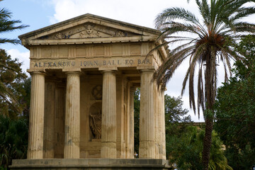 Naklejka premium VALLETTA, MALTA - DEC 31st, 2019: The Lower Barrakka Gardens with palm trees and clear blue sky