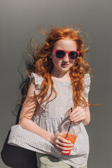 Obraz premium Redhead girl standing under the hot sun