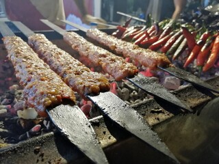 Cooking Adana kebabs on the restaurant style grill