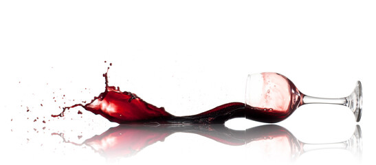 Burgundy red wine pouring onto a reflective white surface