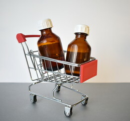 Two brown glass bottles in the cart. The concept of shopping in an online store.