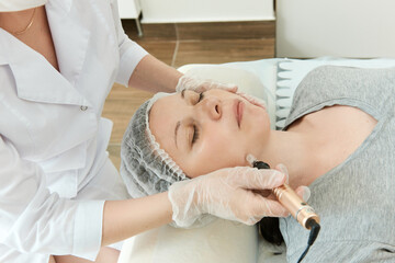 Fototapeta na wymiar Cosmetic procedure with laser device on girl face.