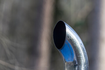 hot exhaust gases flicker in front of the chrome-plated exhaust pipe of a construction machine