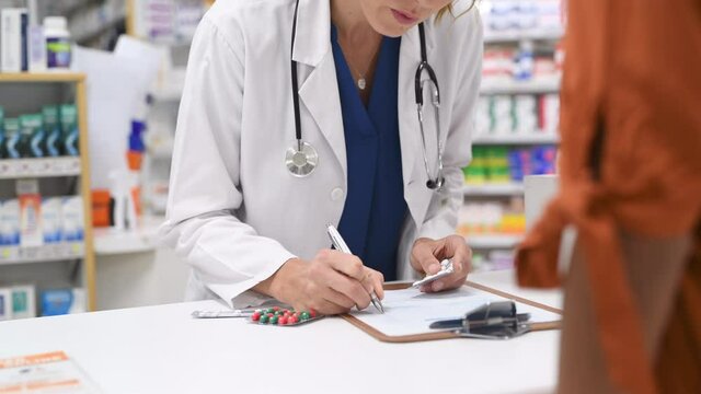 Closeup of woman hands writing medicine inventory. Close up hands of female doctor writing the medicines to be taken on the preoperative model sheet. Pharmacist checking inventory at hospital pharmacy