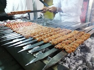 Cooking Adana kebabs on the restaurant style grill