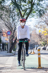 Fototapeta na wymiar Cyclist on a trail bike with a mask on a sunny day.